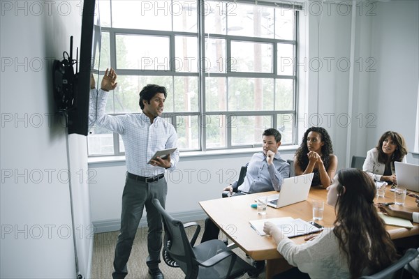 Businessman talking near visual screen in meeting