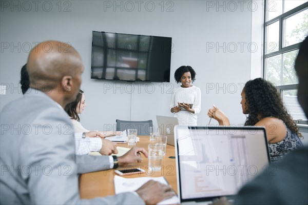 Businesswoman talking near visual screen in meeting