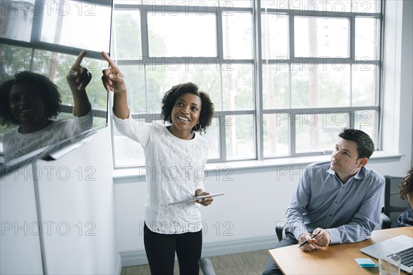 Businesswoman talking near visual screen in meeting