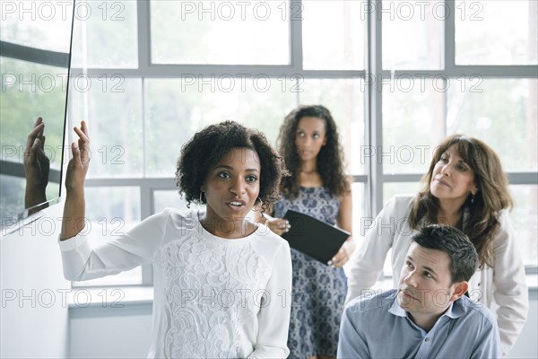 Businesswoman talking near visual screen in meeting