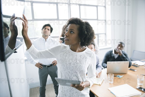 Businesswoman talking near visual screen in meeting