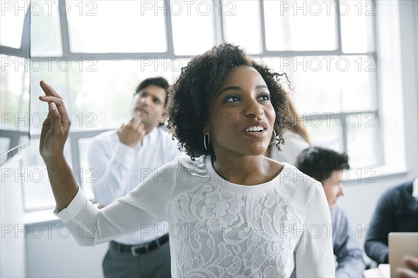 Businesswoman talking near visual screen in meeting