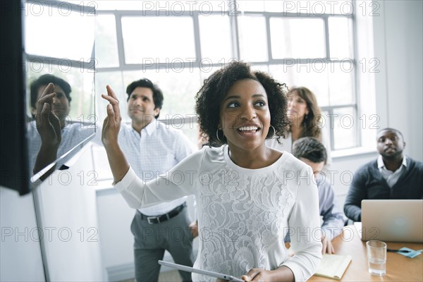 Businesswoman talking near visual screen in meeting