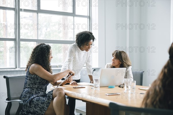 Businesswomen using laptop in meeting