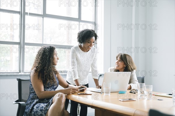 Businesswomen using laptop in meeting