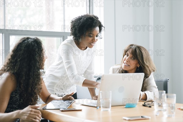 Businesswomen using laptop in meeting