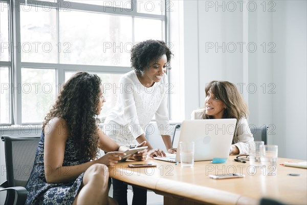 Businesswomen using laptop in meeting