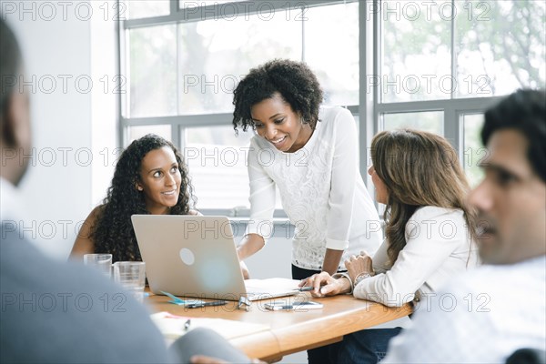 Businesswomen using laptop in meeting