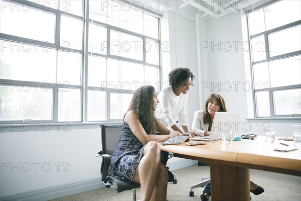 Businesswomen using laptop in meeting