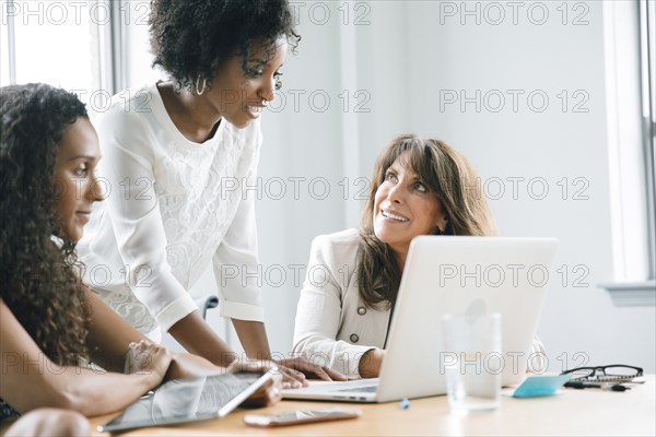 Businesswomen using laptop in meeting