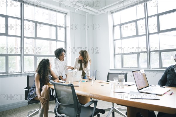 Businesswomen using laptop in meeting