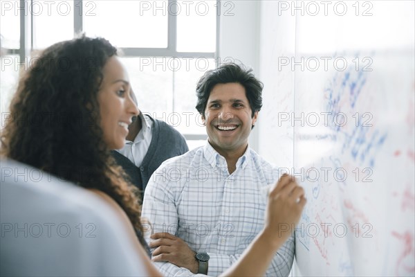 Businesswoman writing on whiteboard in meeting