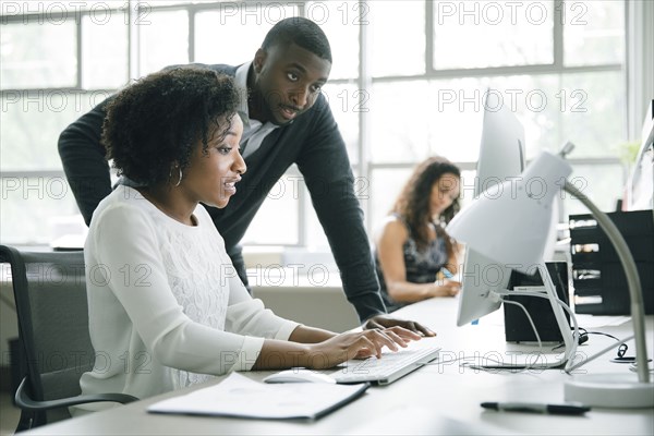 Business people using computer in office