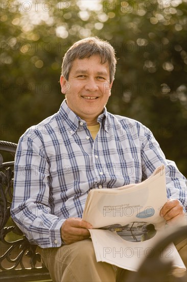 Hispanic man reading newspaper