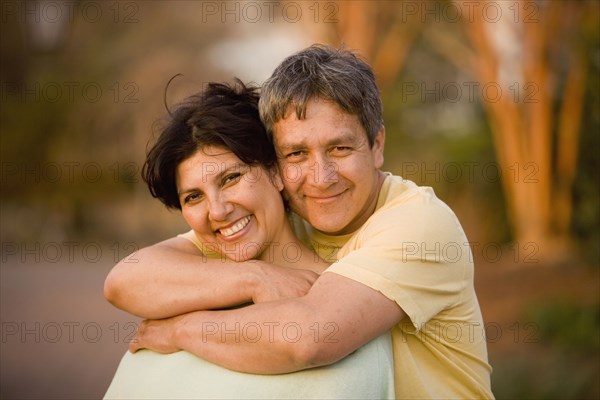 Hispanic couple hugging in park