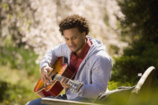 African American man playing acoustic guitar