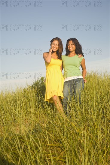 Asian mother and daughter in dune grass