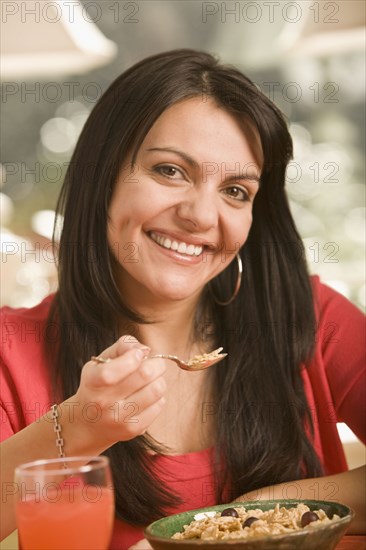 Hispanic woman eating cereal