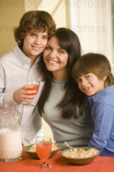 Hispanic mother and sons eating breakfast