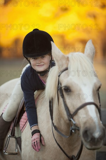 Caucasian girl riding on horse