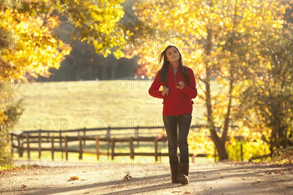 Caucasian girl walking on road in countryside