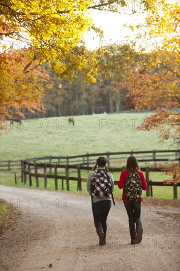 Caucasian girls walking together on road in countryside