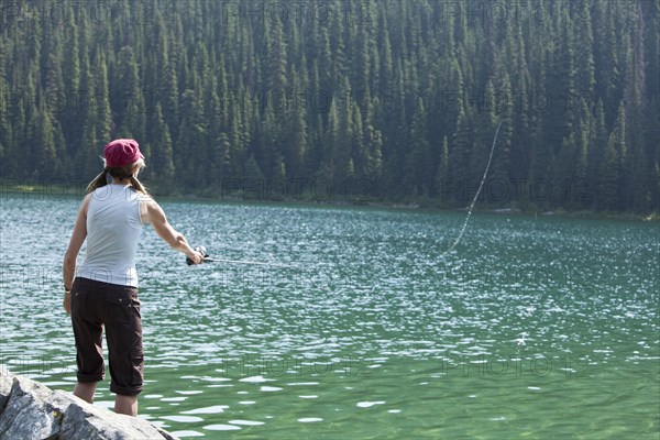 Caucasian woman fishing in lake