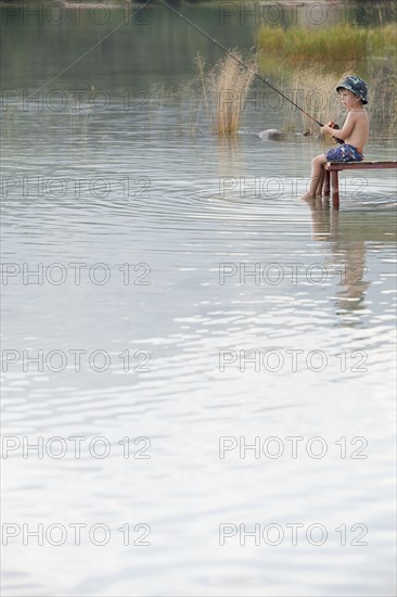 Caucasian boy fishing in lake