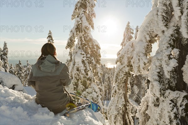 Caucasian woman snowshoeing in remote area taking break