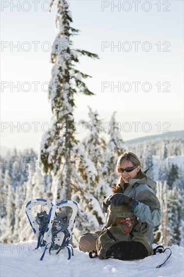 Caucasian woman snowshoeing in remote area taking break