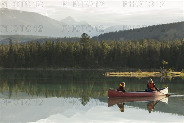Caucasian mother and daughter canoeing on Lake Edith