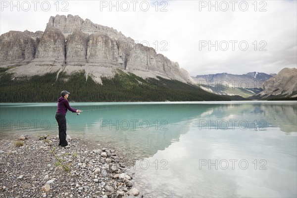 Caucasian woman fishing in Maligne Lake