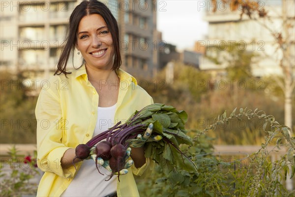 Caucasian woman holding bunch of beets