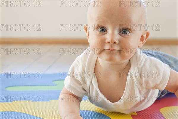 Caucasian baby crawling on plastic mat