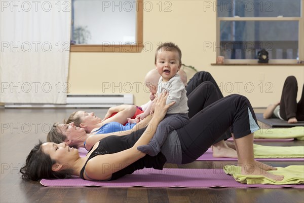 Mothers and babies taking yoga class