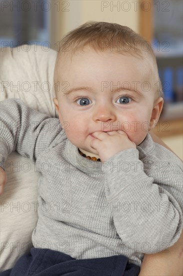 Caucasian baby chewing fingers