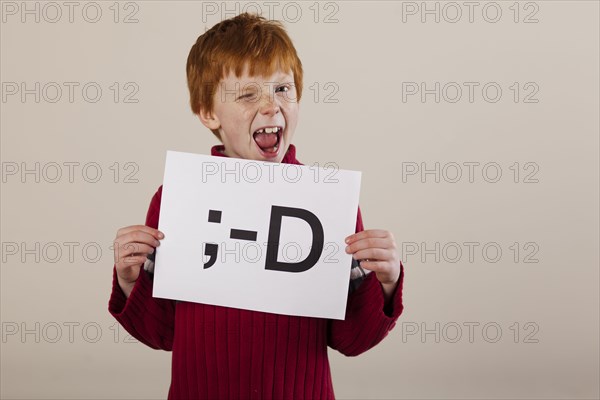 Caucasian boy holding card with smiley face