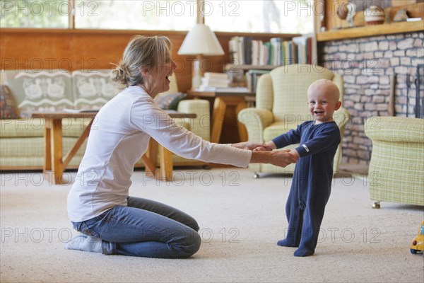 Caucasian mother and baby playing in living room