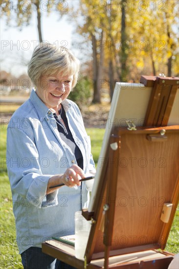 Senior woman painting outdoors