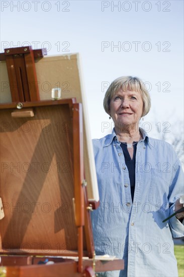 Senior woman painting outdoors