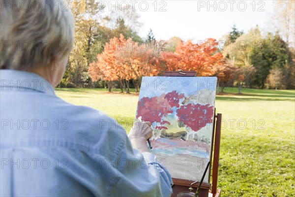 Senior woman painting outdoors