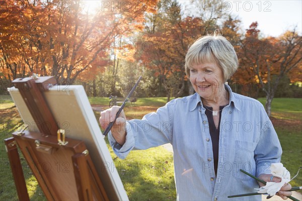 Senior woman painting outdoors