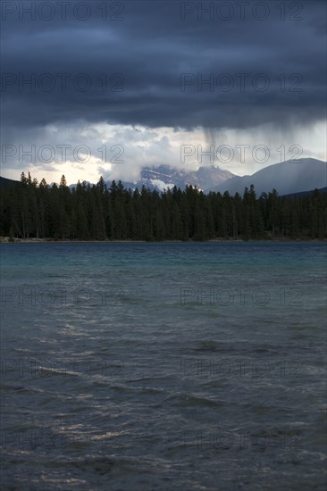 Storm clouds raining over lake