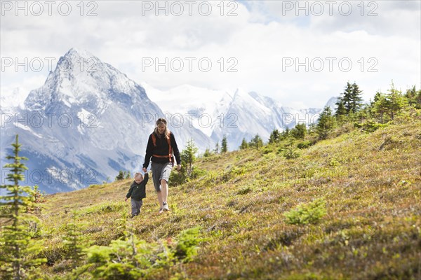 Caucasian mother and son hiking on remote hillside