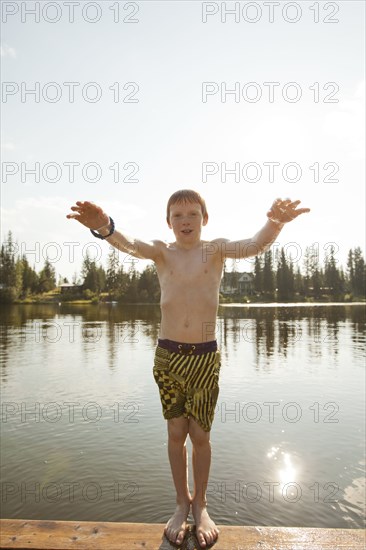 Caucasian boy falling backwards into lake