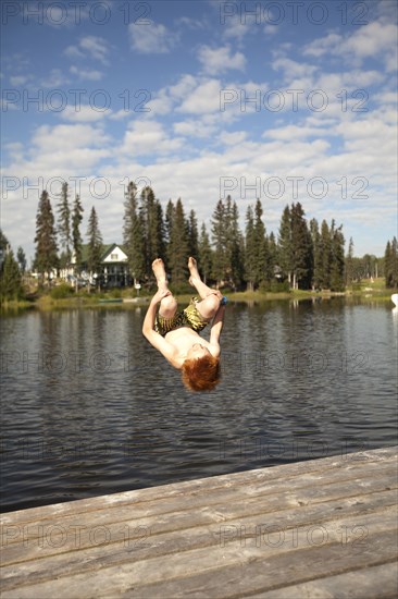 Caucasian boy jumping into lake