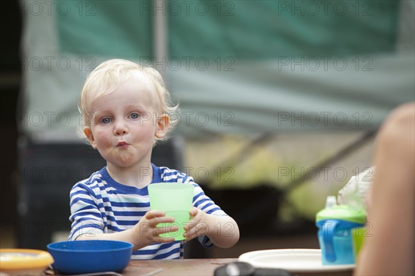 Caucasian boy eating at campsite