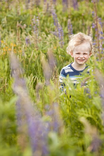 Caucasian boy walking in tall grass