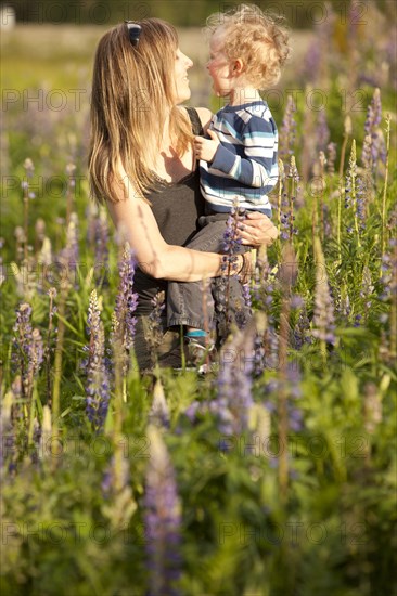 Caucasian mother hugging son in tall grass