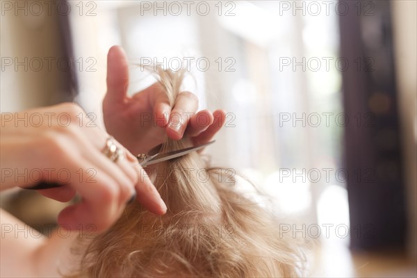 Caucasian mother cutting hair of son